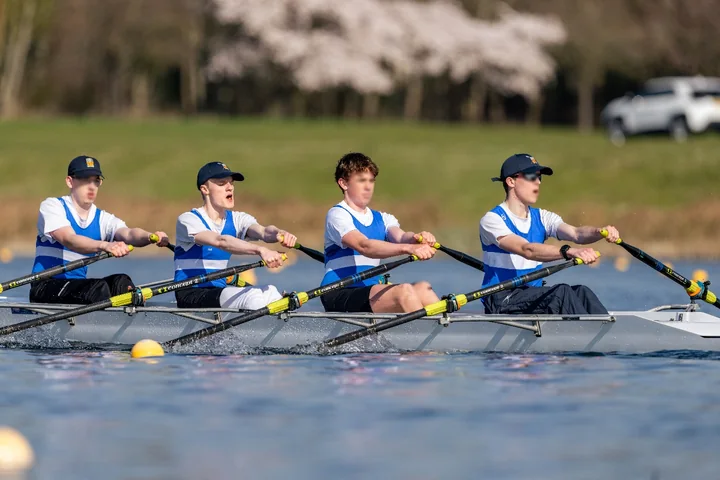 Four rowers racing on the water
