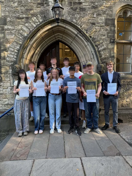 A group of students outside a stone arch